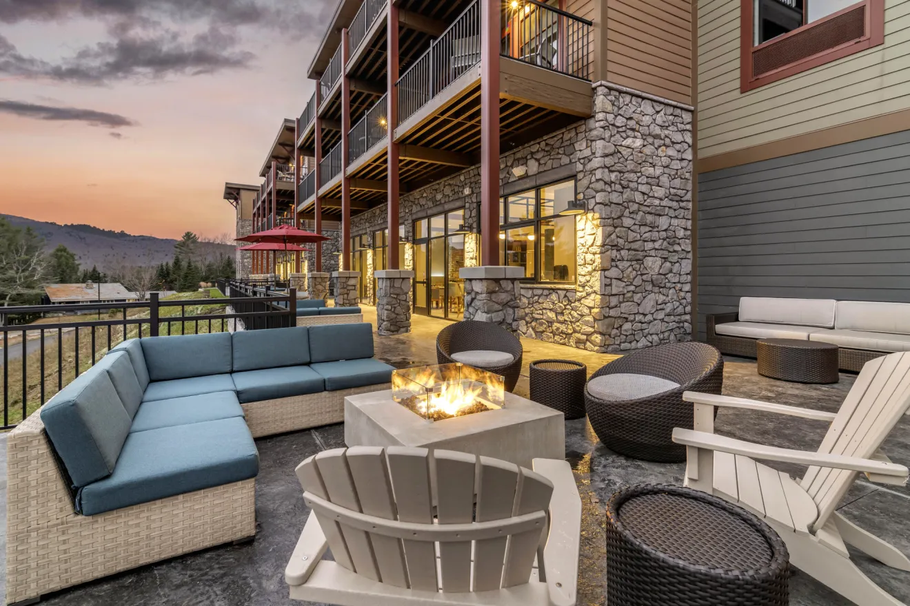 Outside seating area and fire pit at Cambria Hotel at sunset