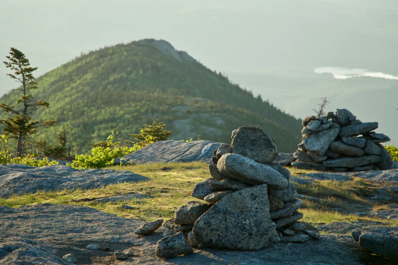 A pile of rocks on a hiking trail. 