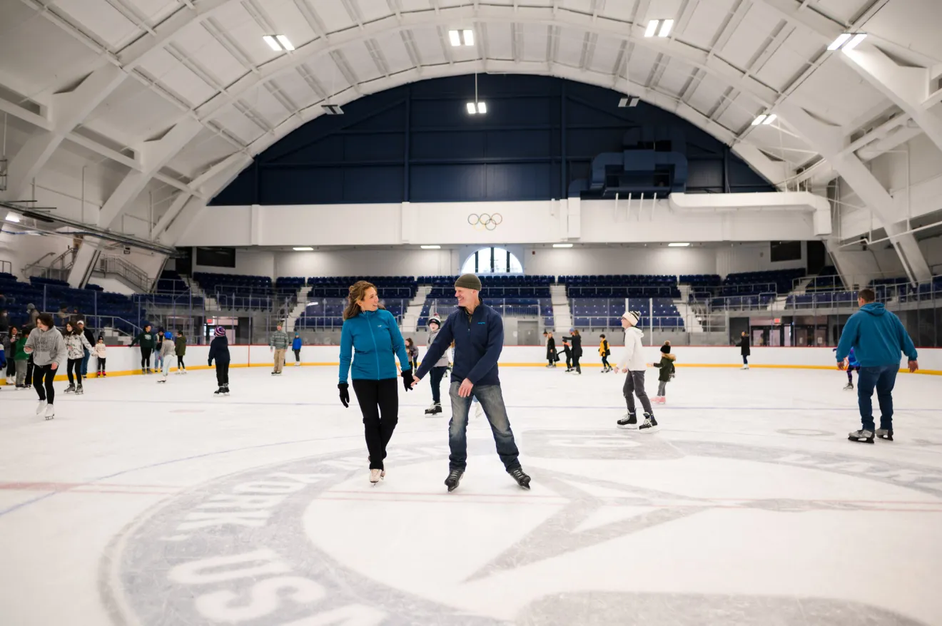 A couple ice skates in an ice skating rink. 