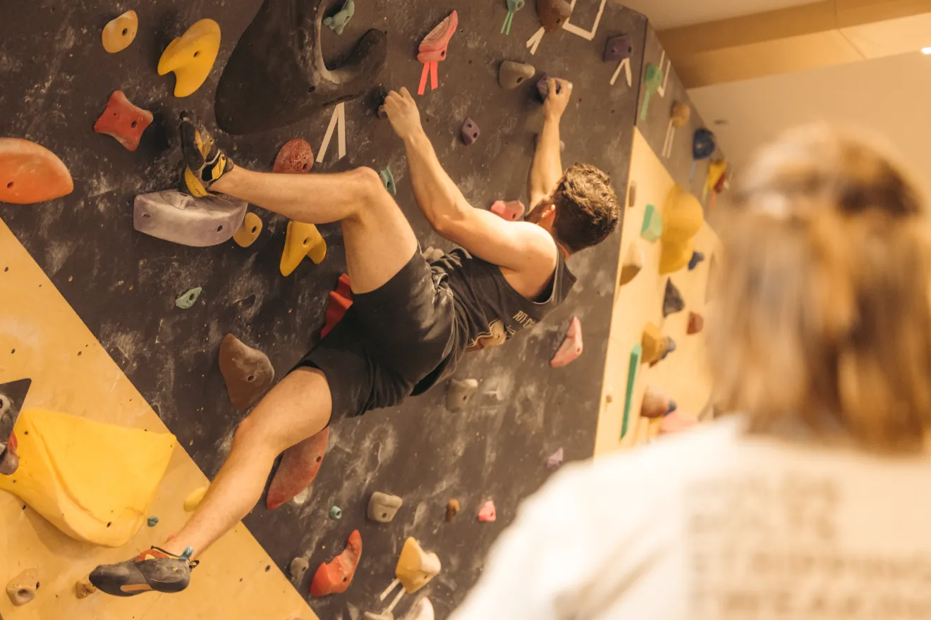 A man climbs an indoor rock wall. 