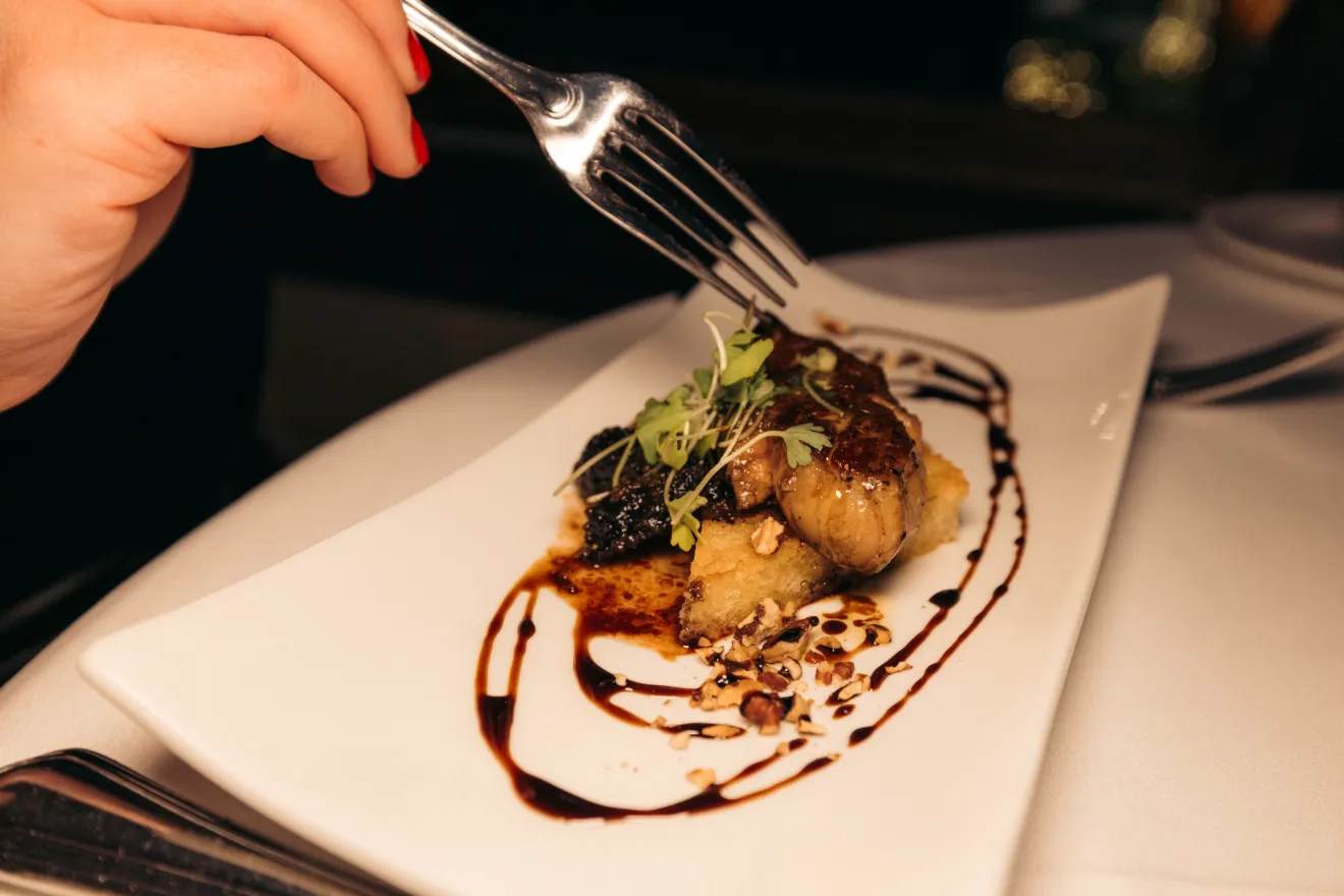 A plate of high end food on a white square plate. 
