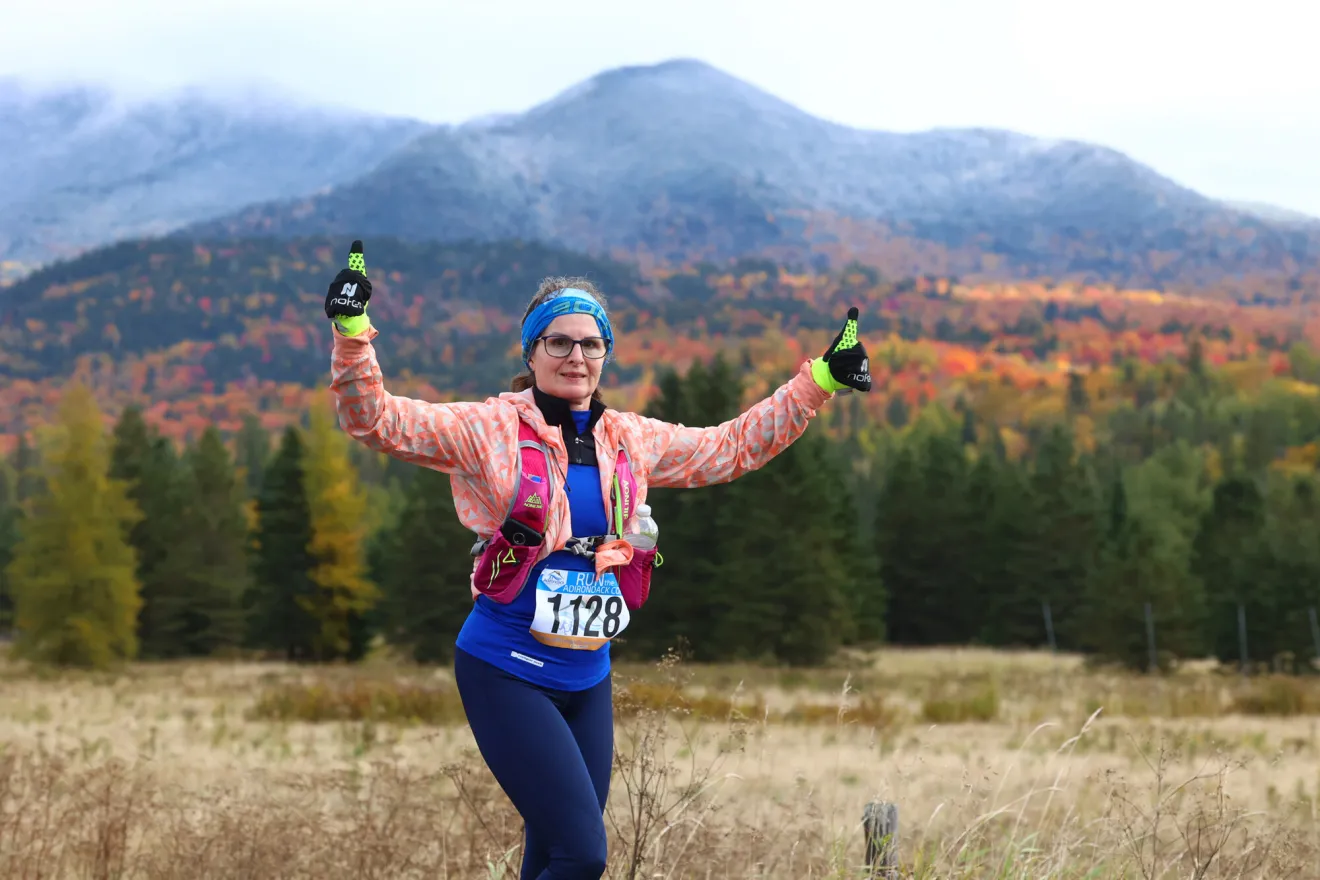 A woman running in the Lake Placid Classic Half Marathon during the fall.