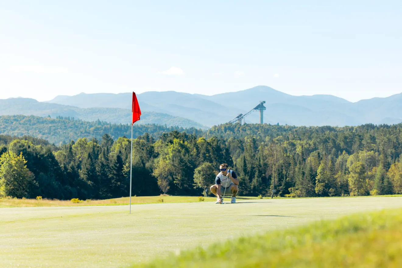 A golfer preparing to tee off on a Lake Placid golf course.