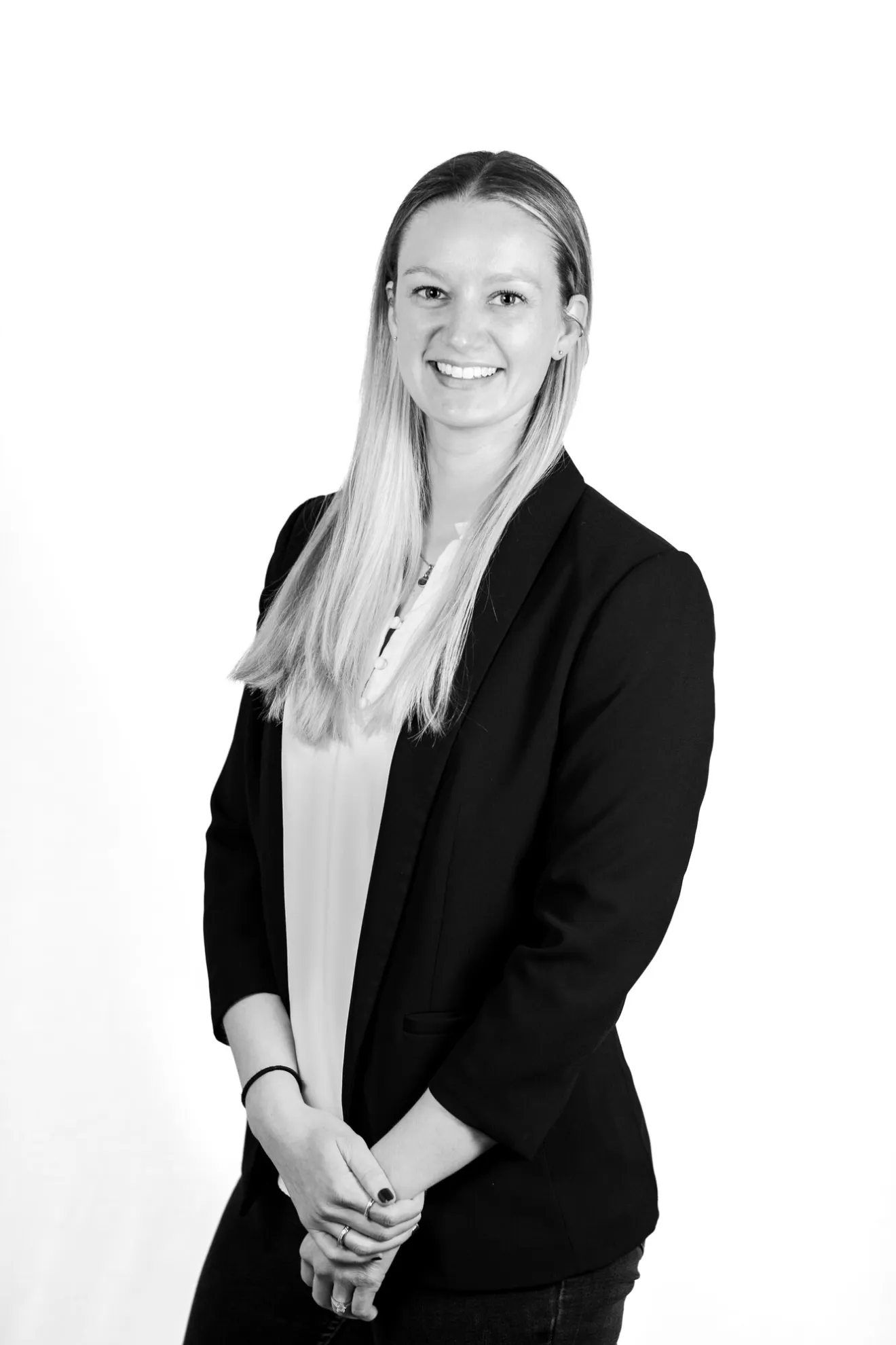 A woman smiles for a photo in a black and white photo.