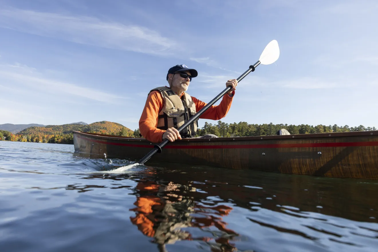 A man paddling a solo canoe