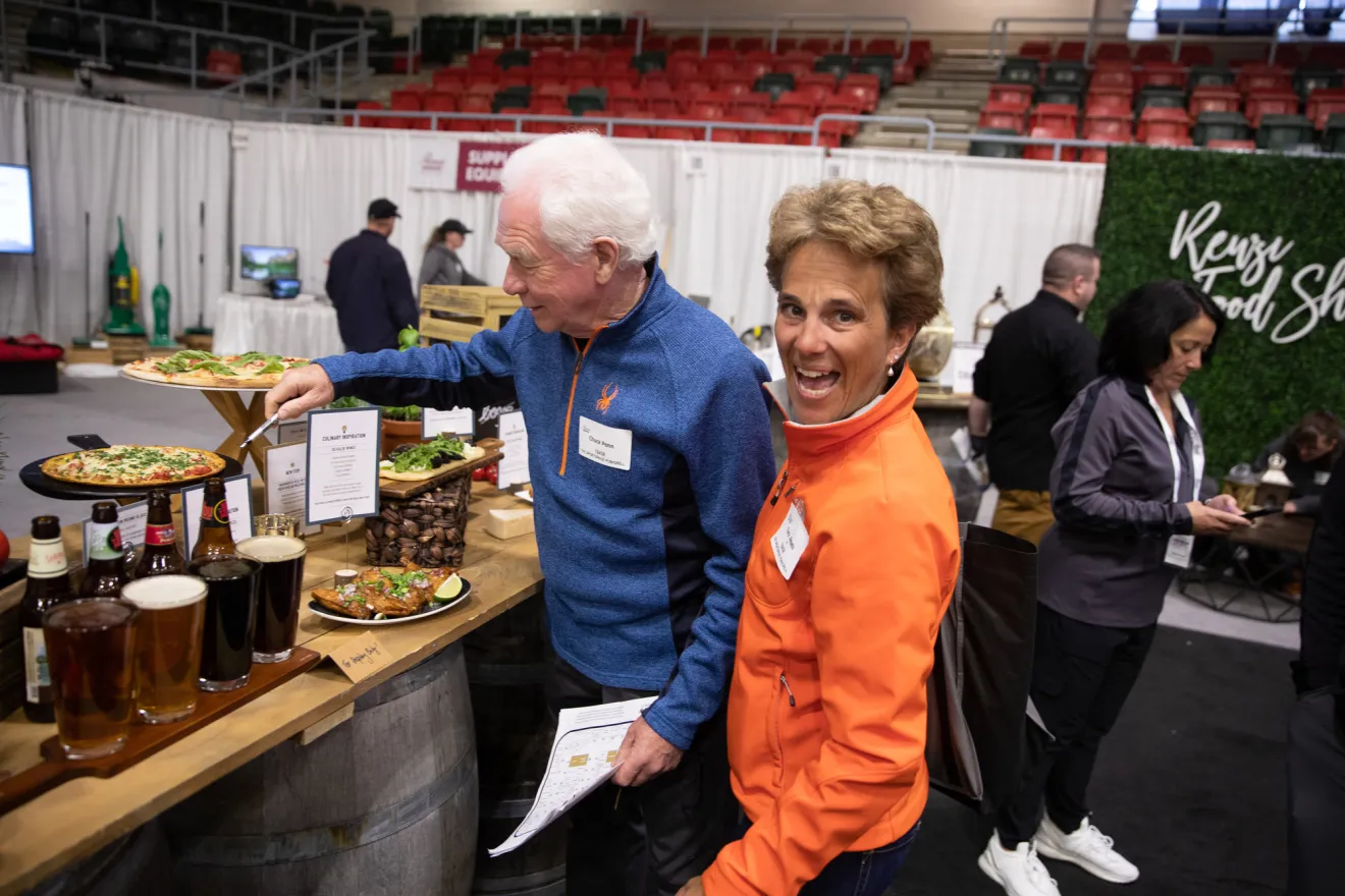 A woman smiles at the camera at a food show. 