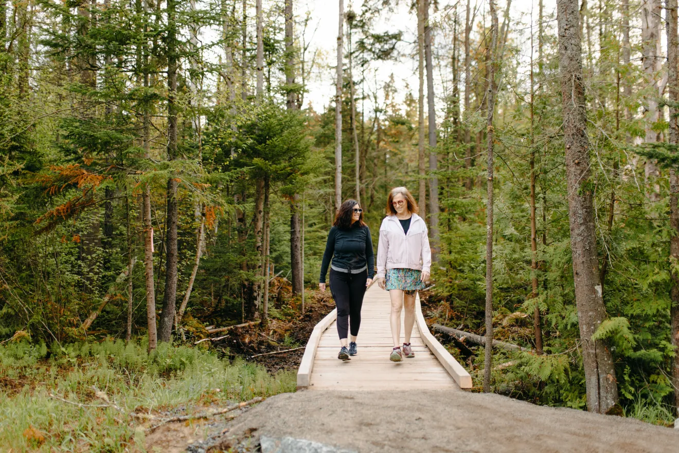 Two women walk a nature trail together. 