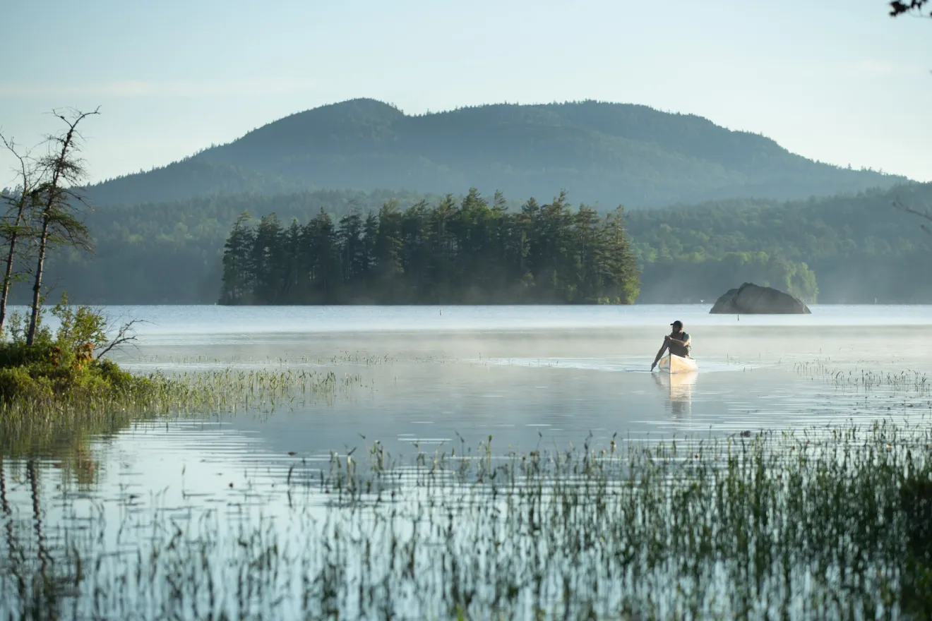 a man paddles on a lake 