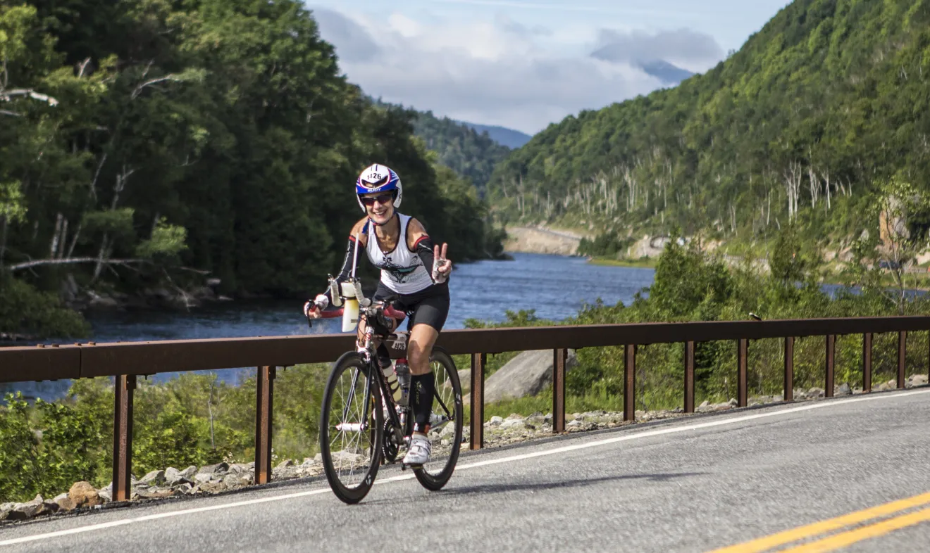 An Ironman athlete rides her bike past the Cascade Lakes