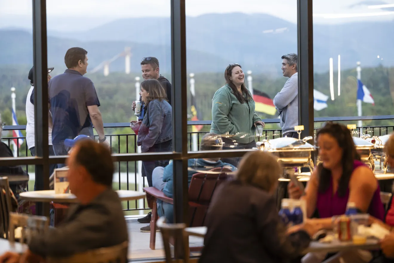 People speak to each other outside on a corporate deck. 