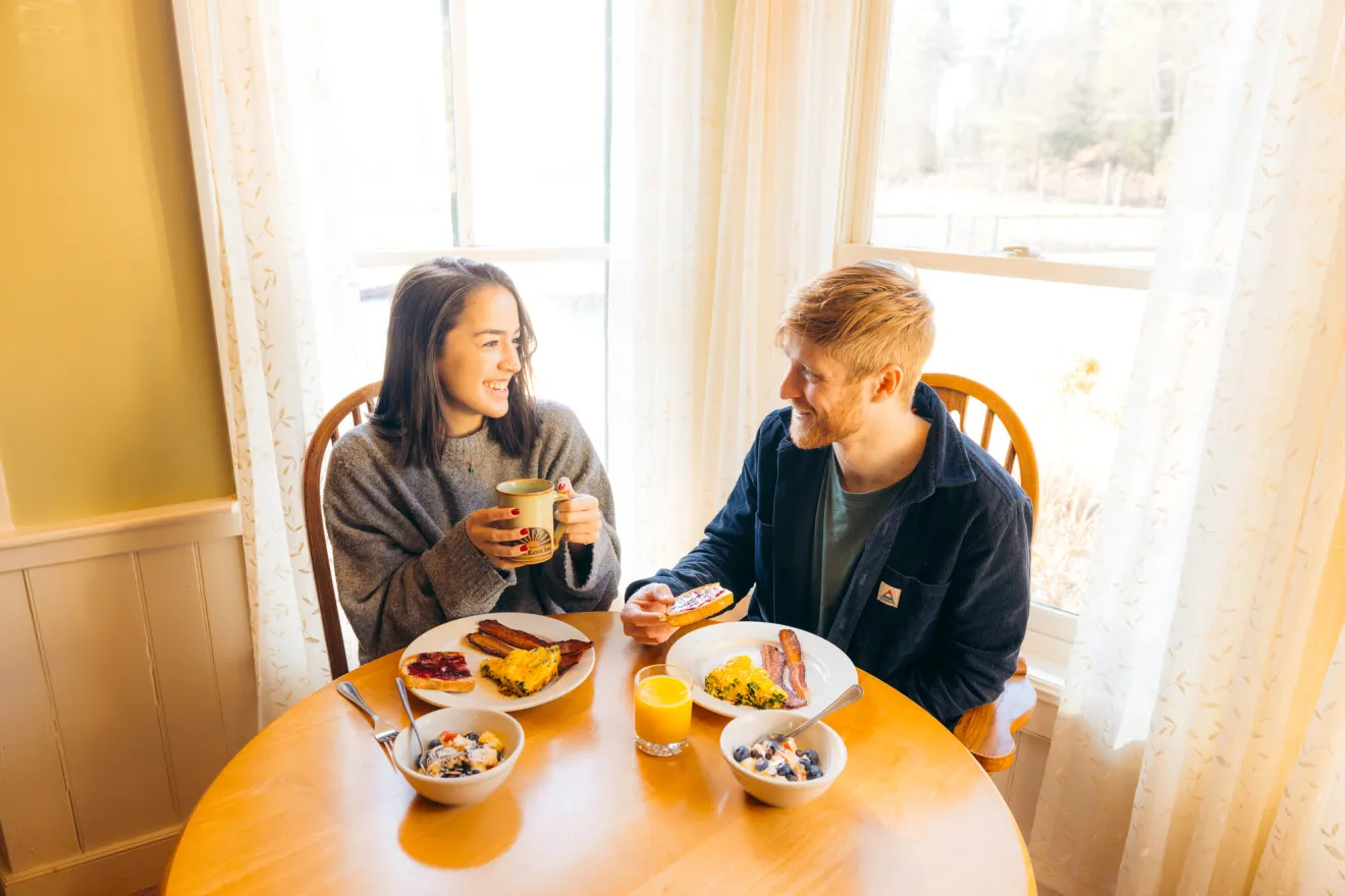 A man and woman share breakfast in a rental home. 