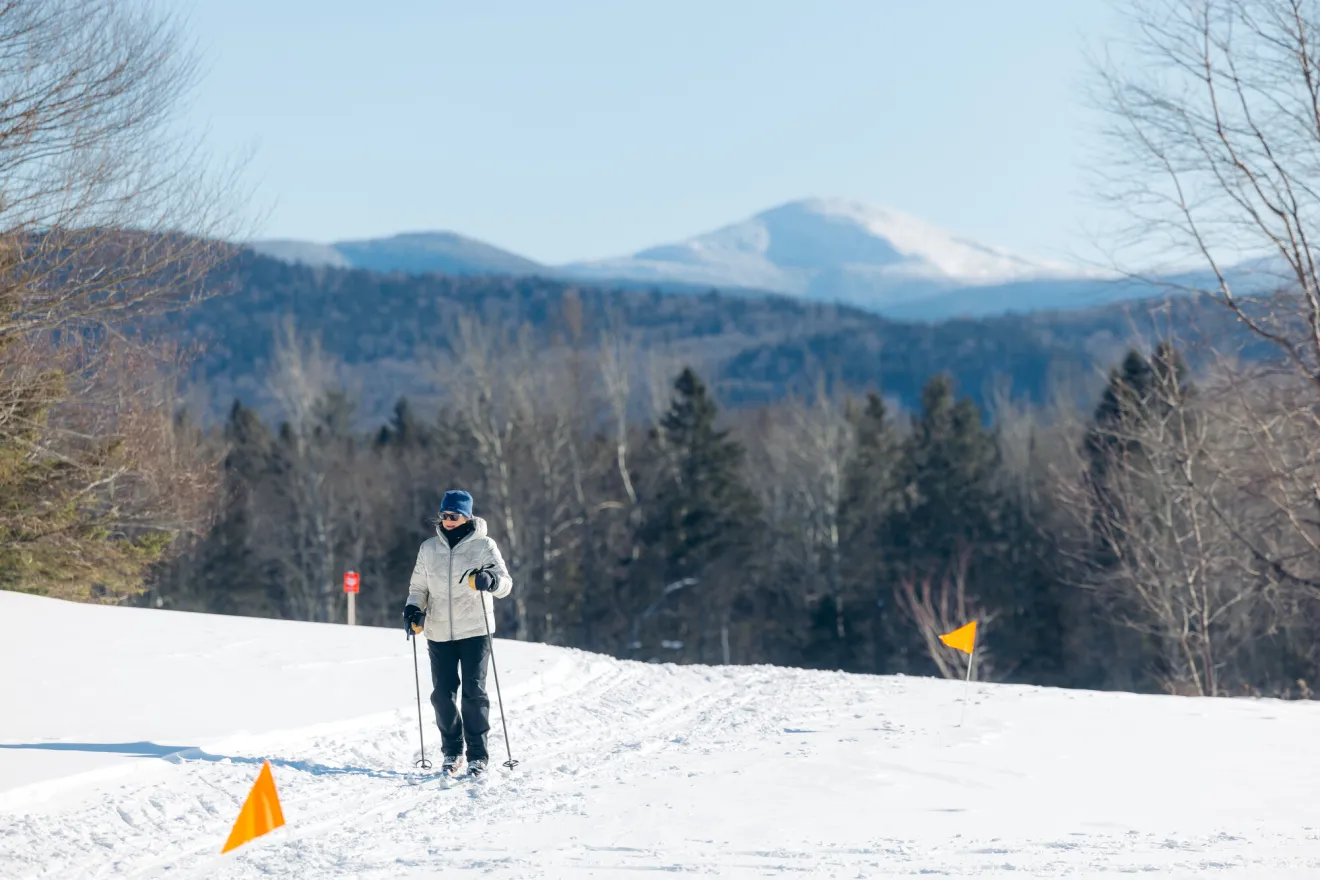 a woman cross-country skis on a golf course.