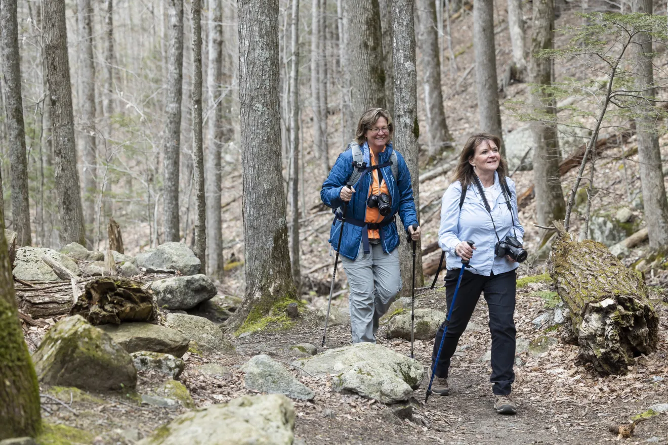 Two woman hiking on a trail in the forest