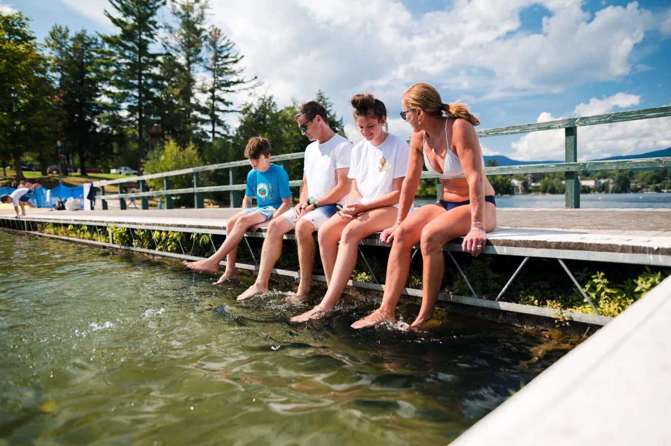 A family sits on a dock together. 