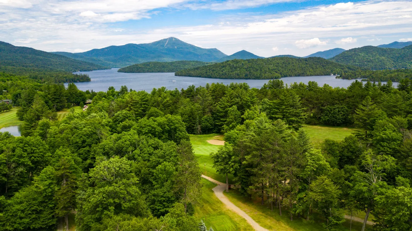 A Lake Placid golf course in the summer with mountain views.