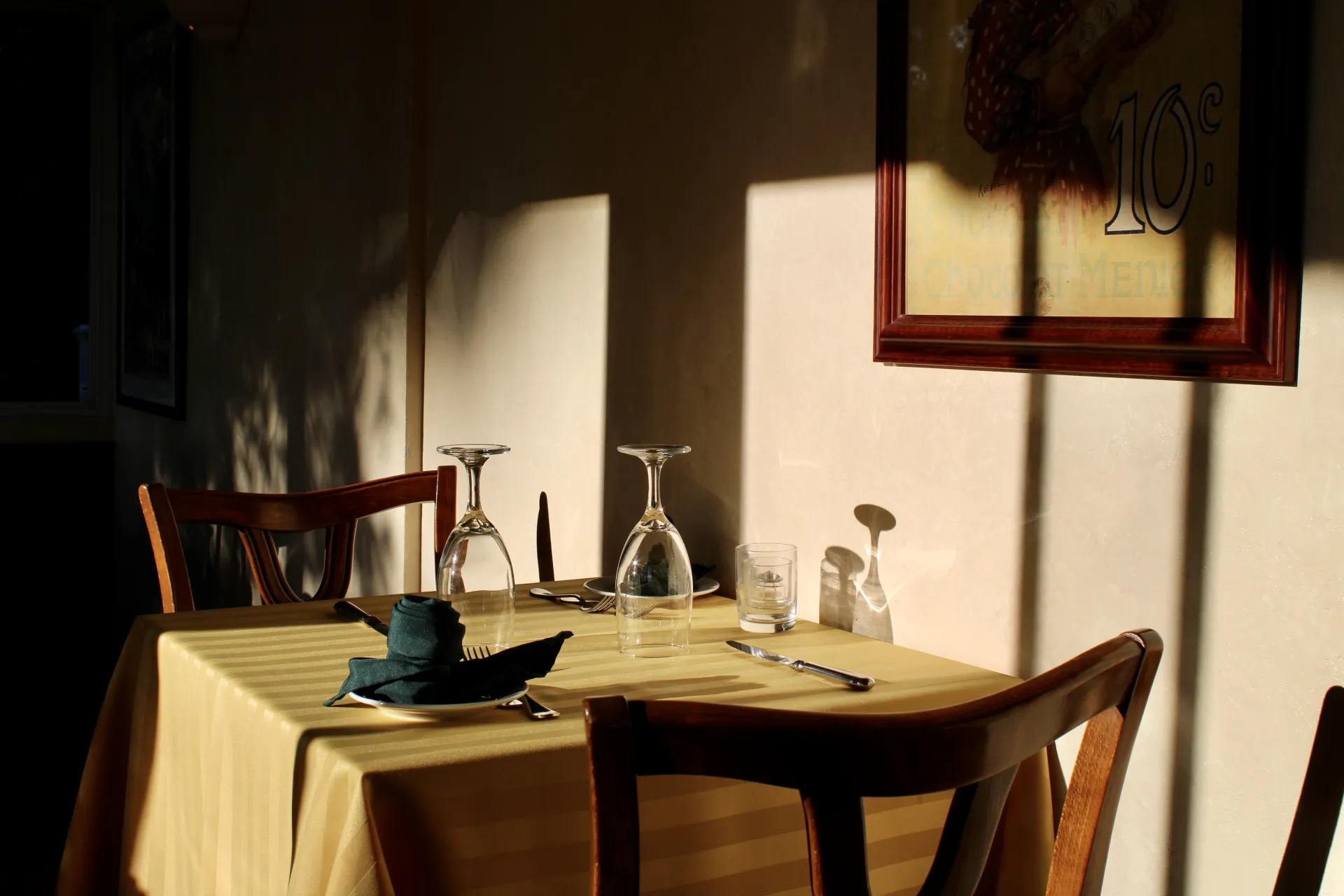 A shadowy scene in the dining room at golden hour.