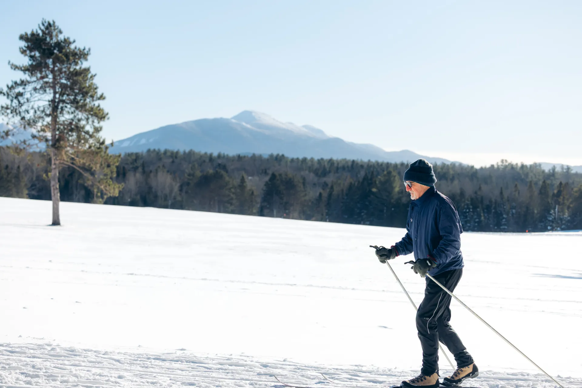 A man cross-country skis in winter.