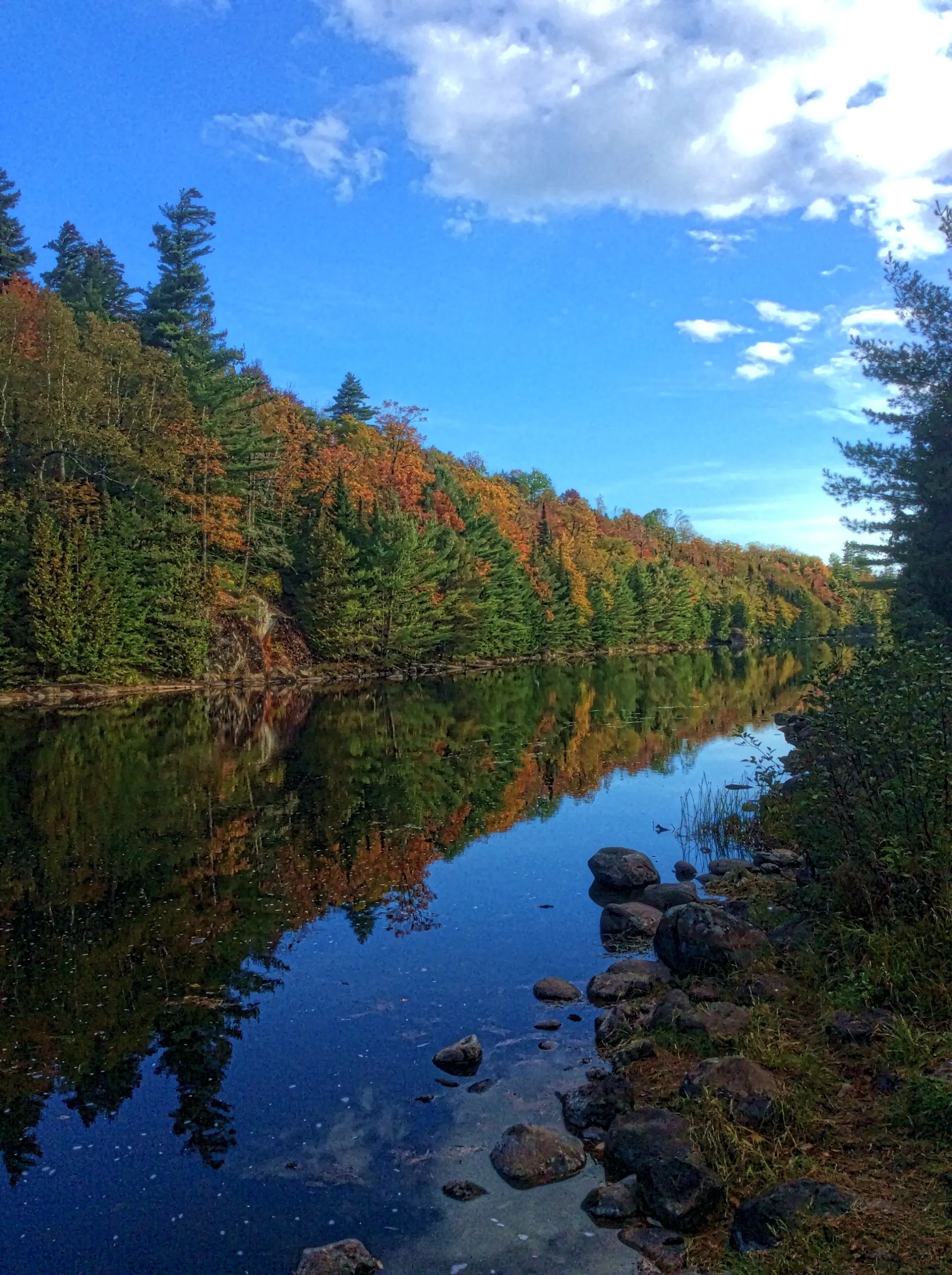 The road continues past the river, upstream of the dam.