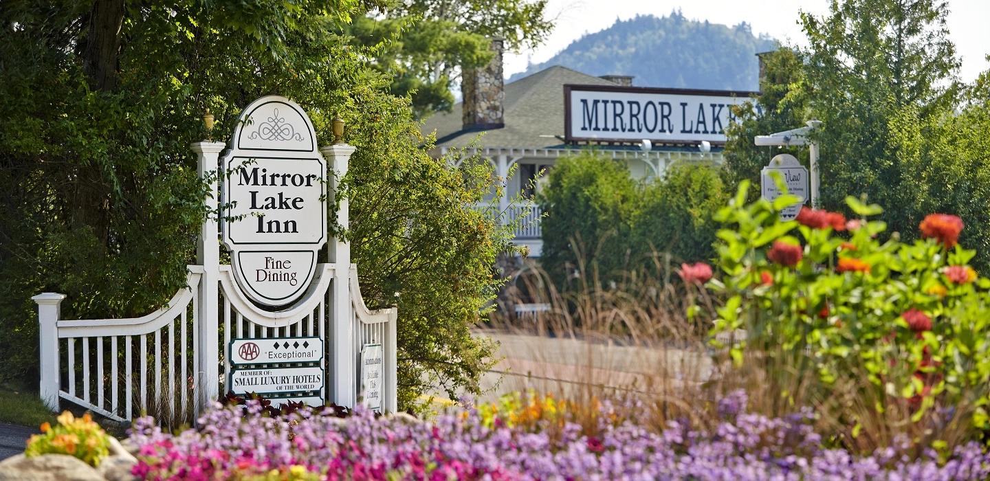 Image of the entry way with sign and glorious colorful summer flowers