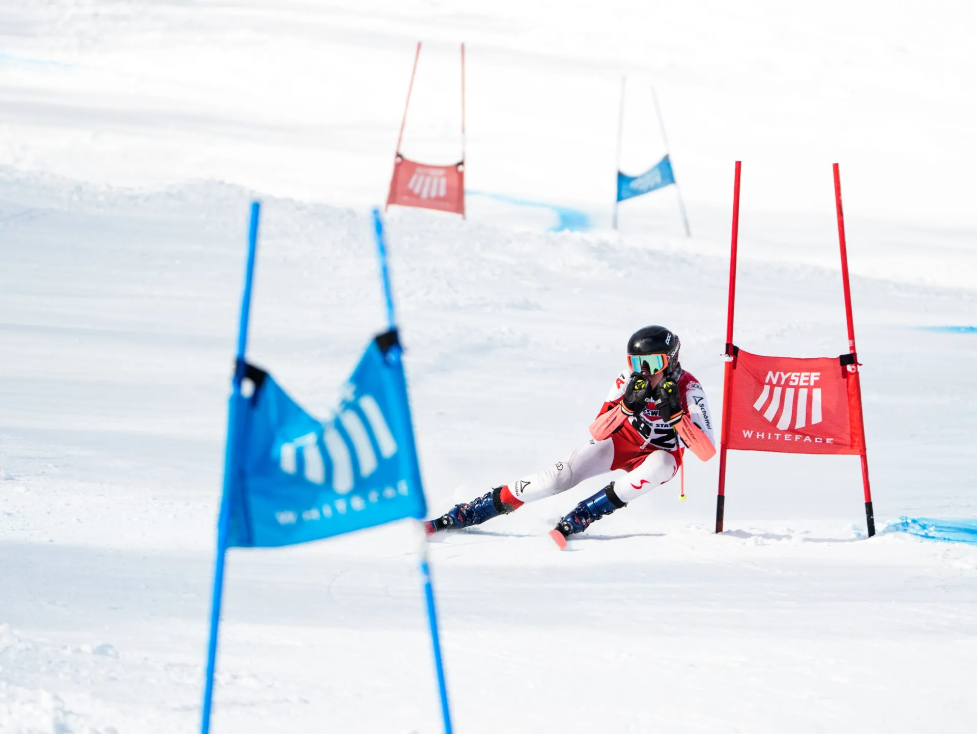 A young skier in action, racing past blue and red flags at Whiteface Mountain ski resort/