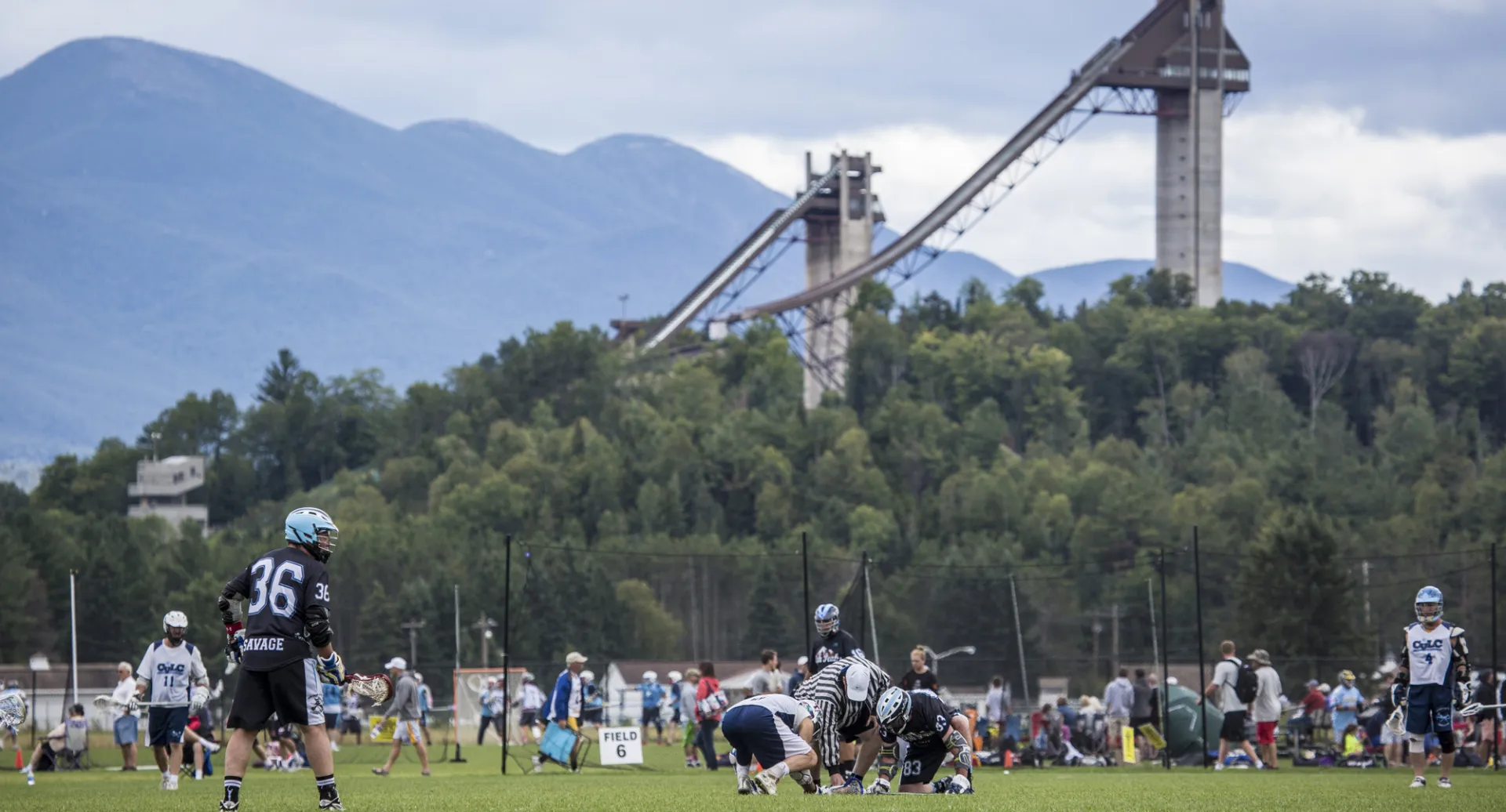The Olympic Ski Jumps in the background of the playing fields at the Horse Show Grounds where the game is beginning.