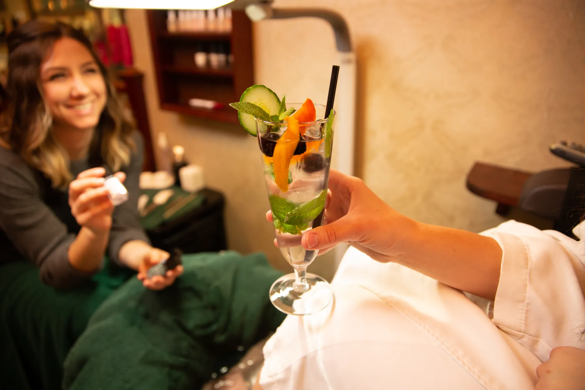 A pedicurist holds different colored polishes for a client to decide.
