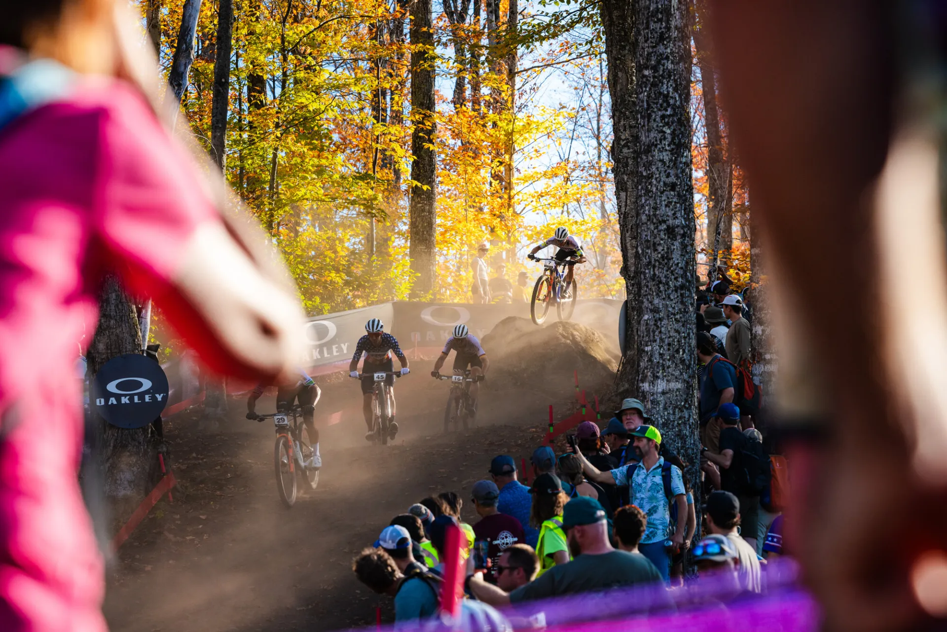 Spectators look on as mountain bikers race down cross-country course at Mt Van Hoevenberg during UCI World Cup race