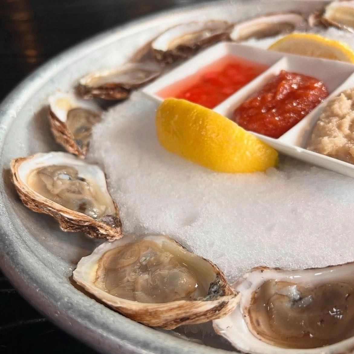 Oysters on a plate with lemon and sauces