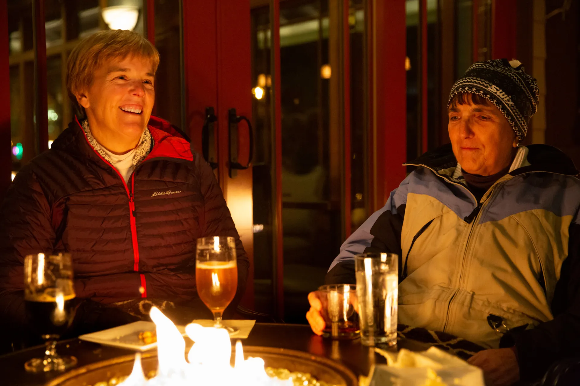 People enjoying cocktails by a fire for the Lake Placid Film Festival.