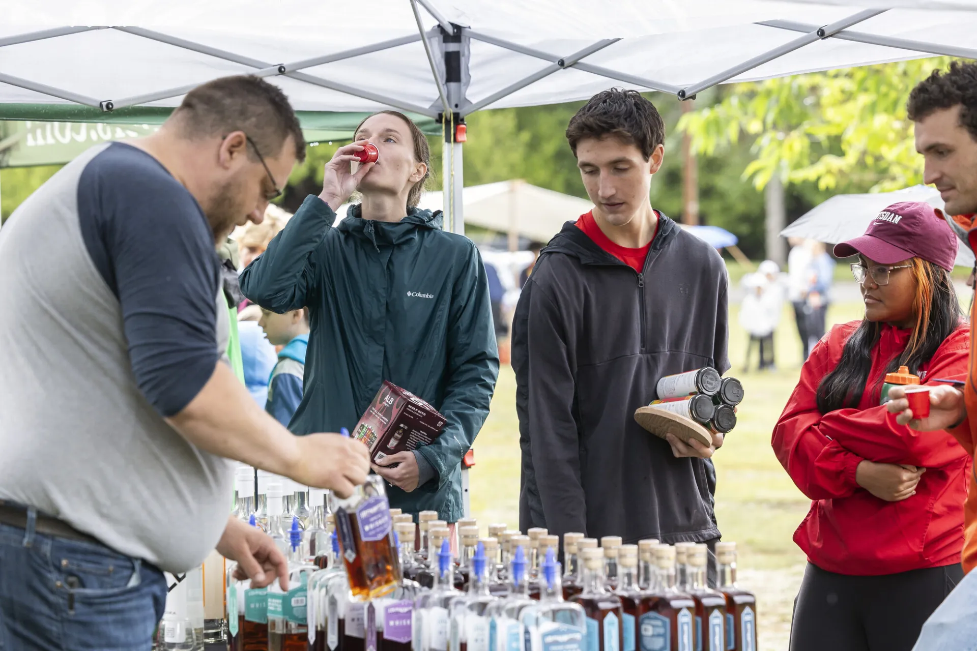 Guests sample whiskey as vendor pours