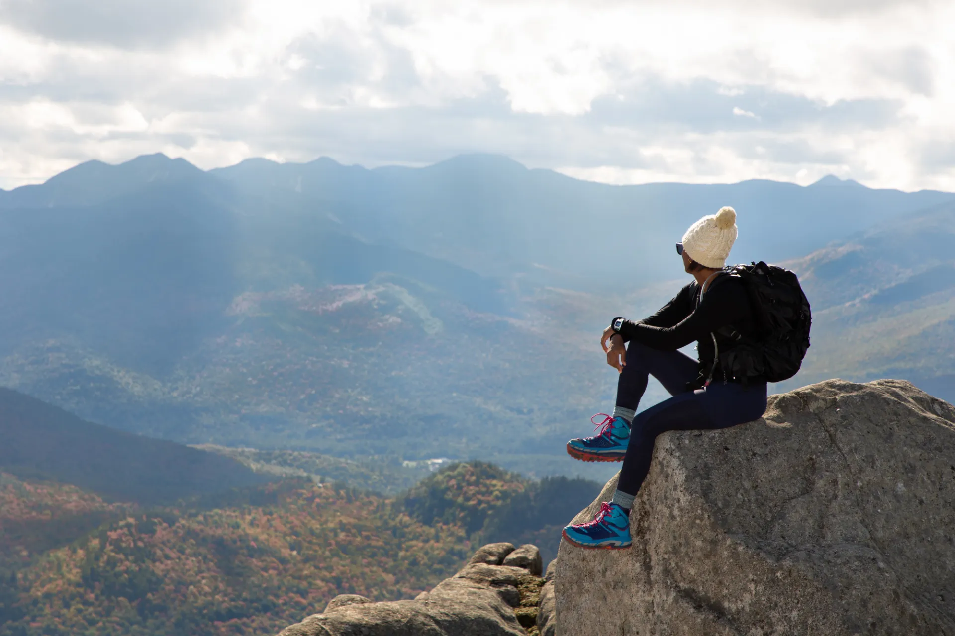 A person at the summit of a hike in Keene during summer.