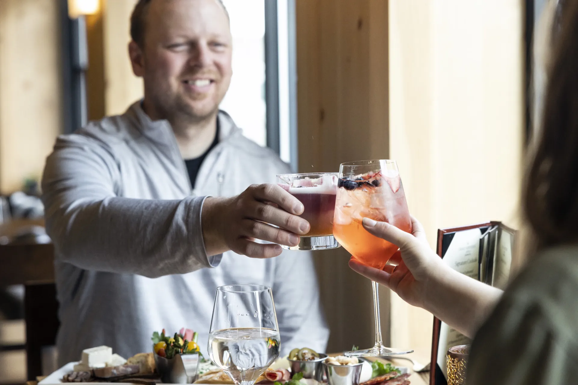 Couple clinking cocktails at dinner table