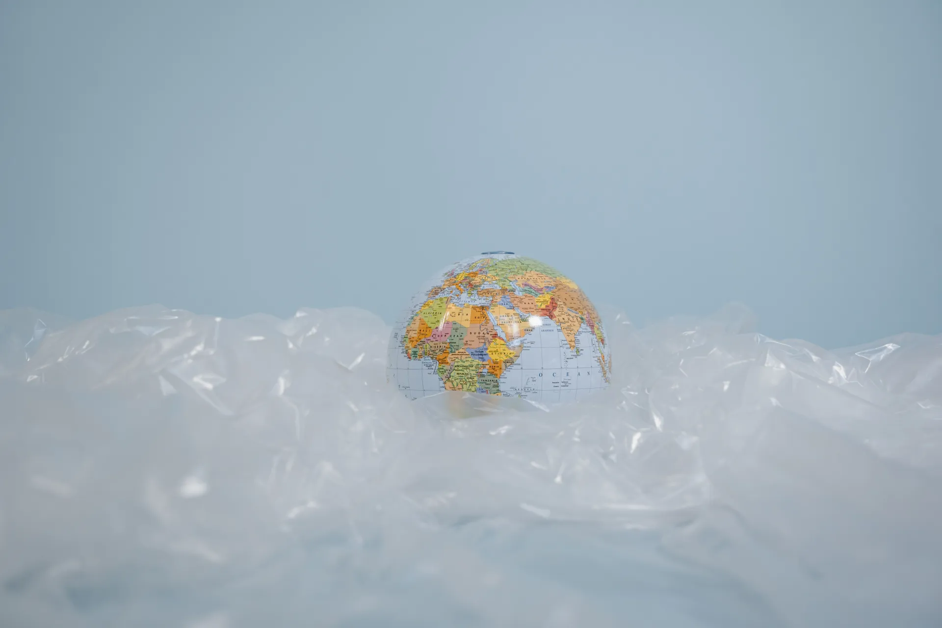 Stock image of small globe sitting atop scrunched plastic