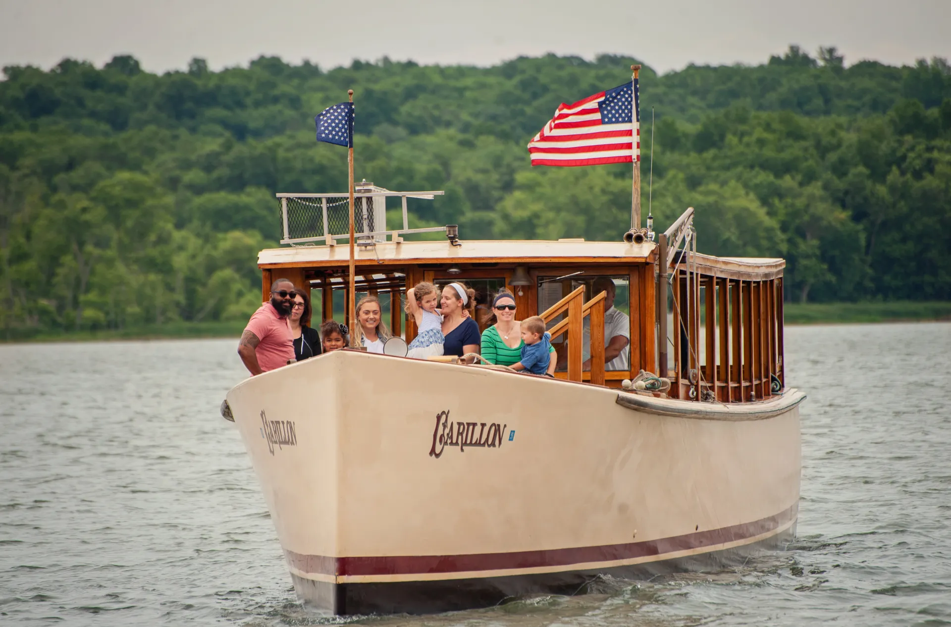 People stand on the bow of the Carillon during their cruise.