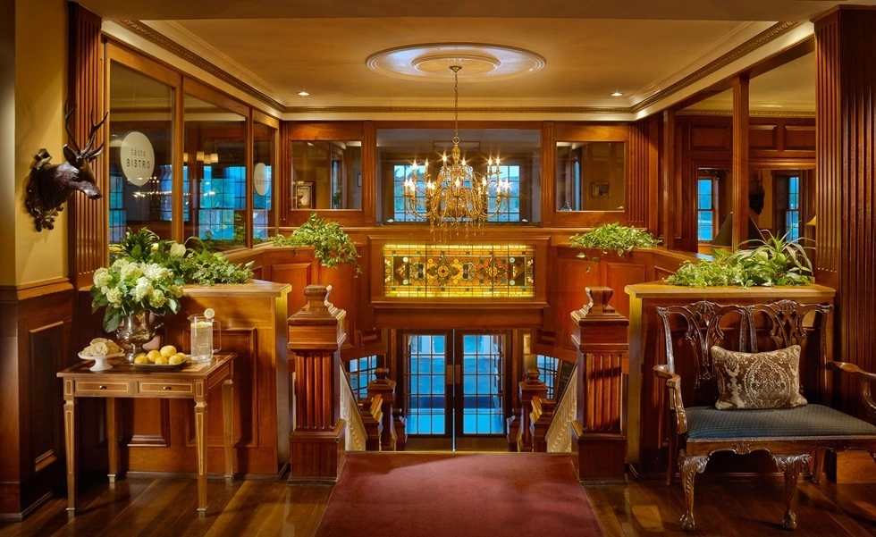 Grand entry with dark wood paneling.