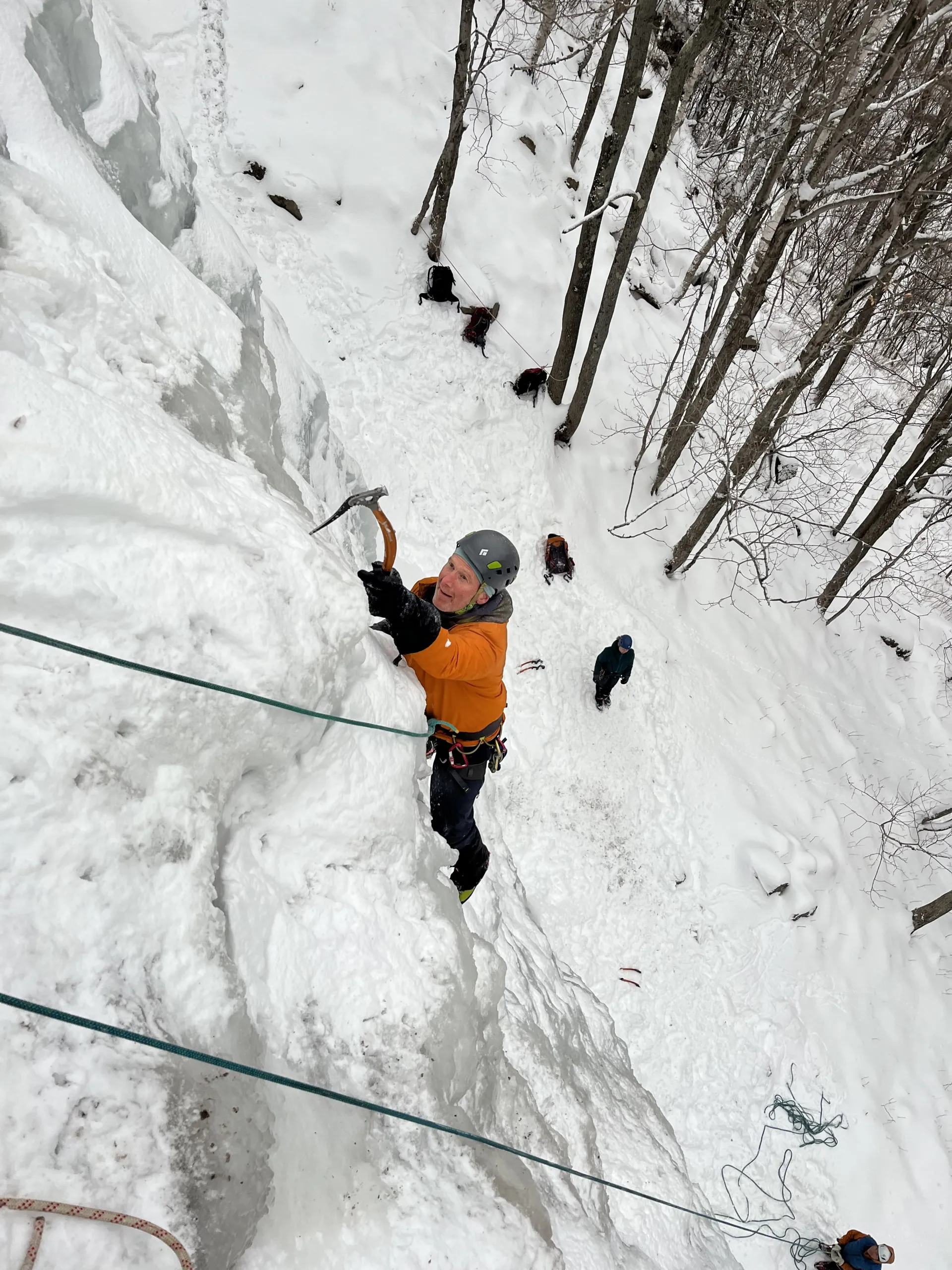 Man with an ice pick ascends an ice wall