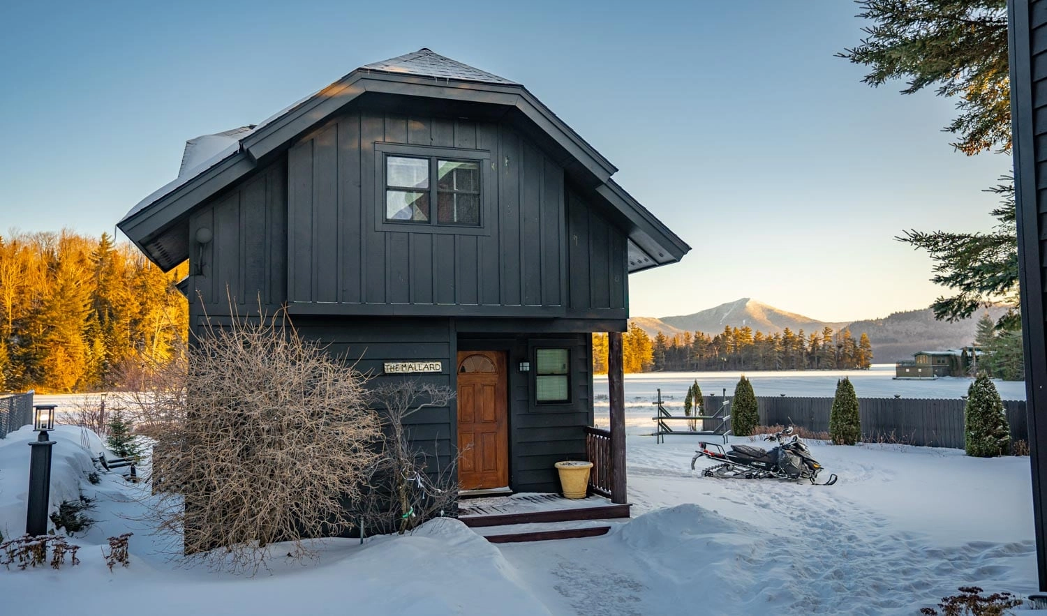 The front of the cabin surrounded by fresh snow.
