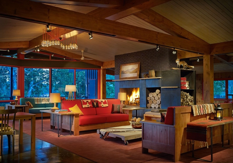 The lobby of Lake House with central fire place, couches and chairs, and amazing views of Mirror Lake.