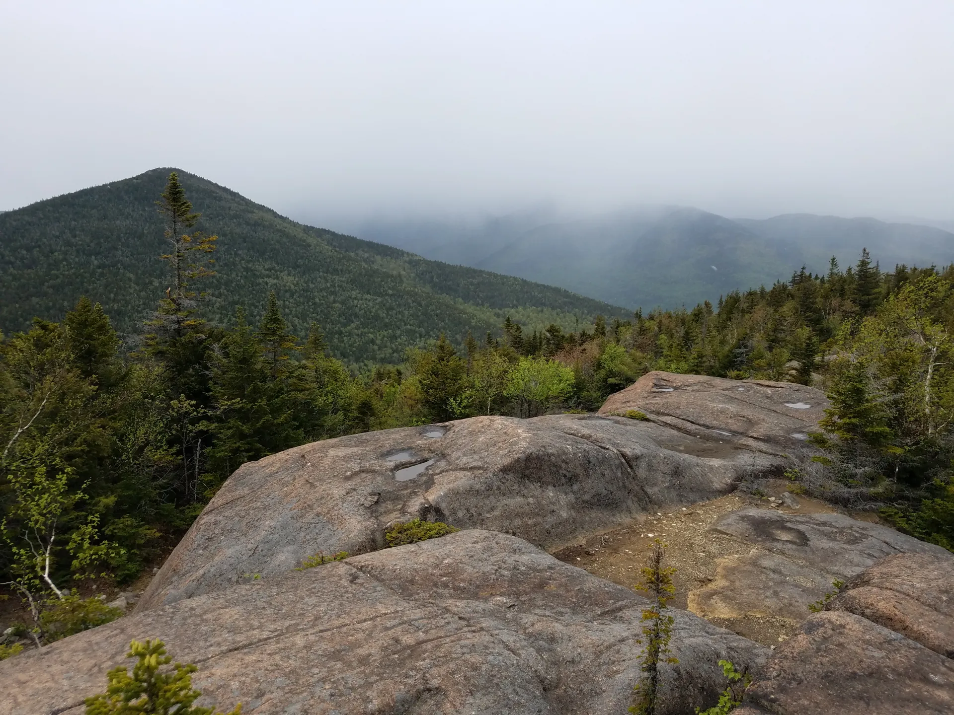 The view of a pointed mountain from a bare rock summit