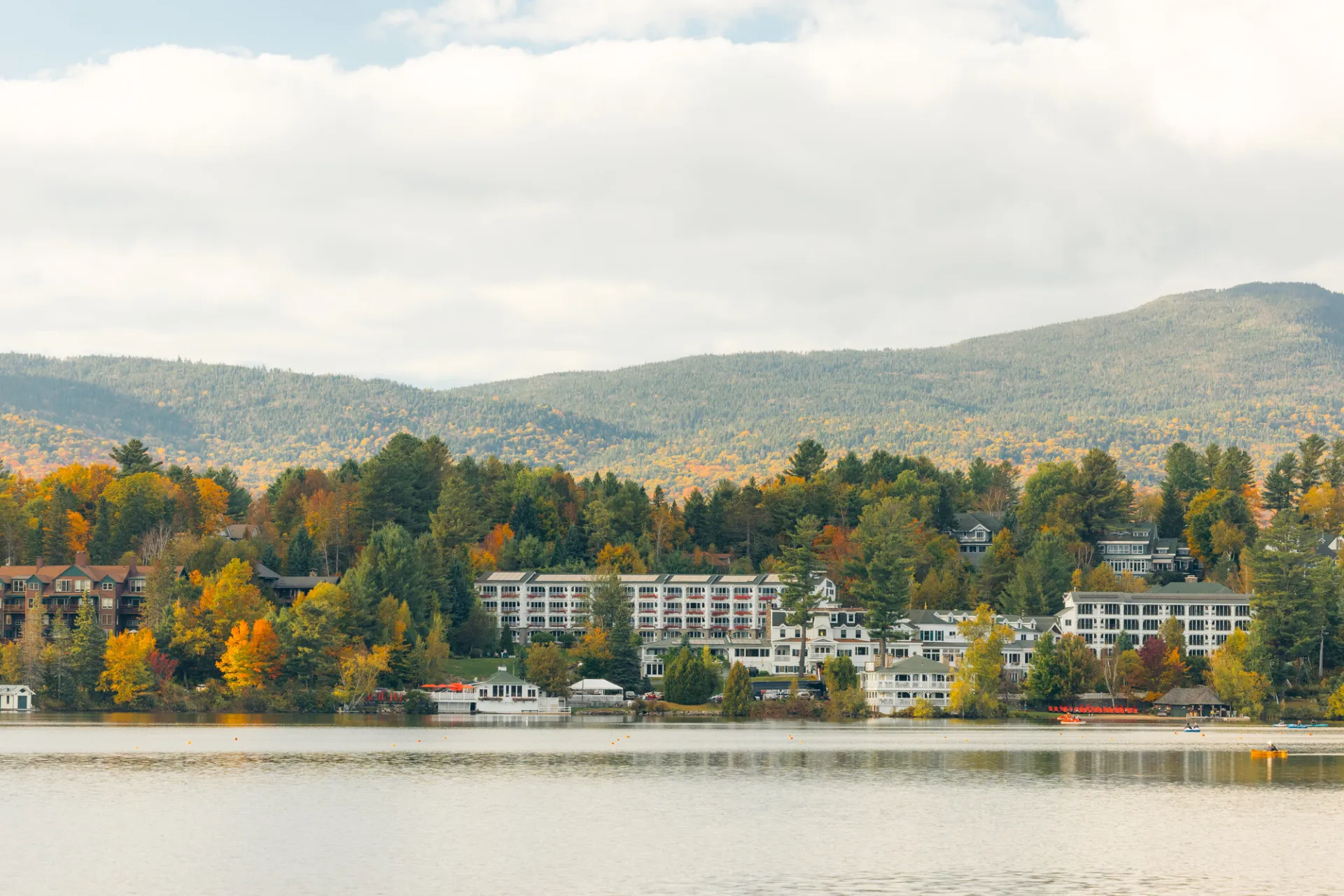 A white hotel on a lake in fall. 
