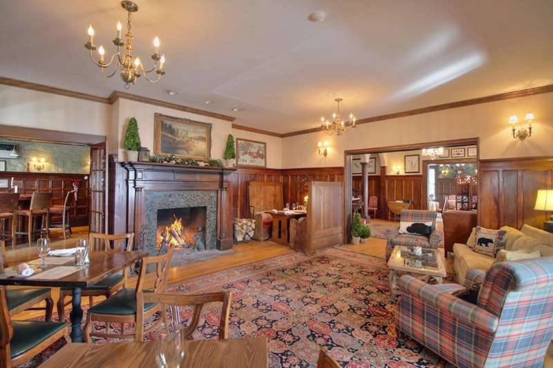 The inviting sitting space by a large fireplace with plush chairs.