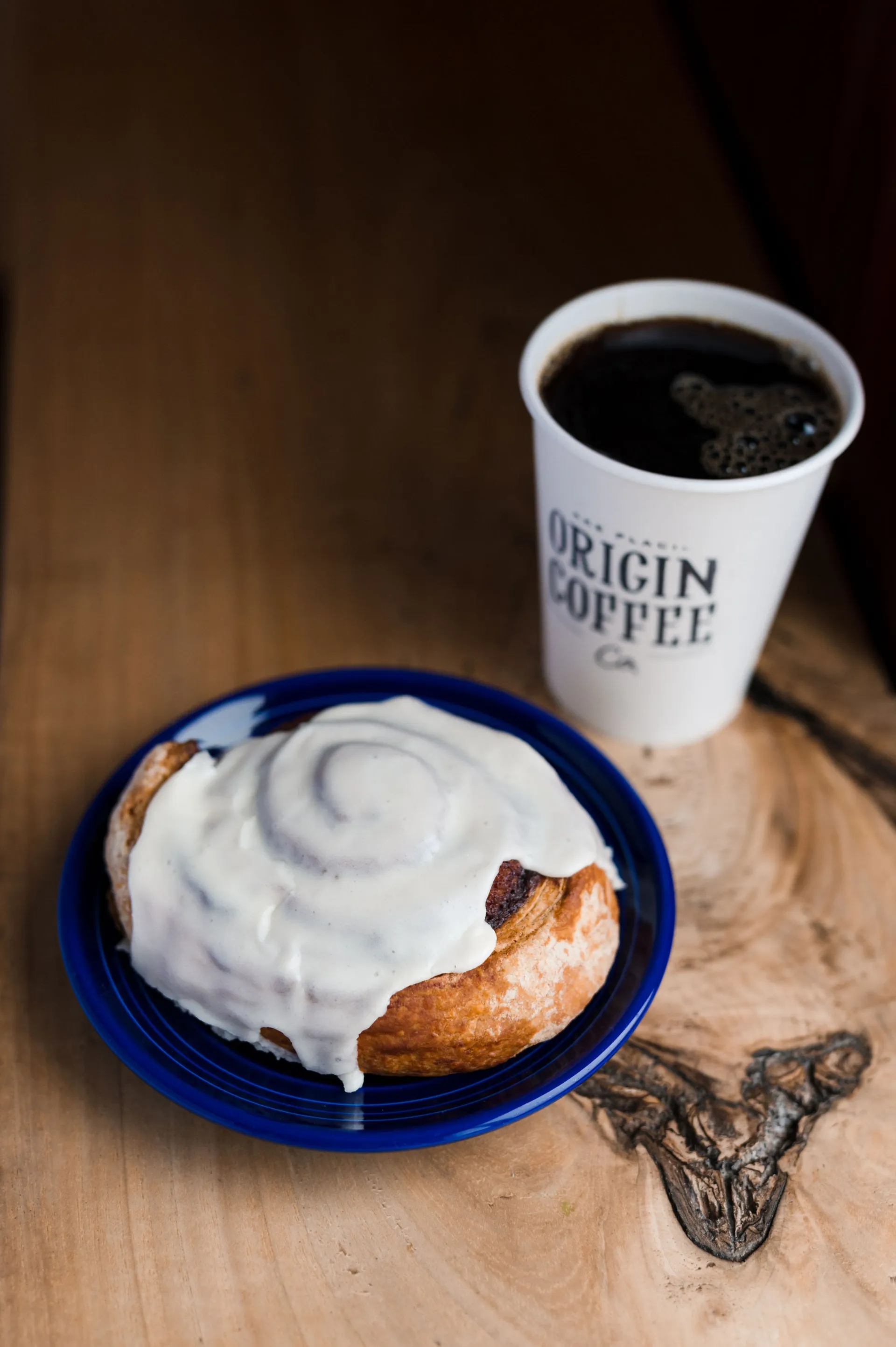 An iced cinnamon bun with a hot coffee