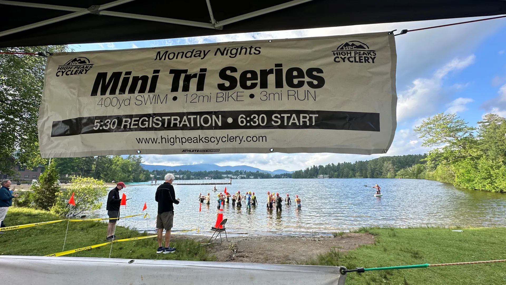 View of mini tri swim start from under pop-up tent with back of banner along top of frame
