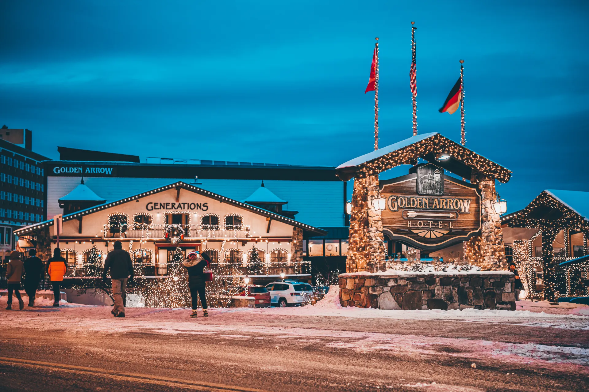 The entry sign for Golden Arrow Lakeside Resort and Generations restaurant all bedecked in warm white lights for the winter.