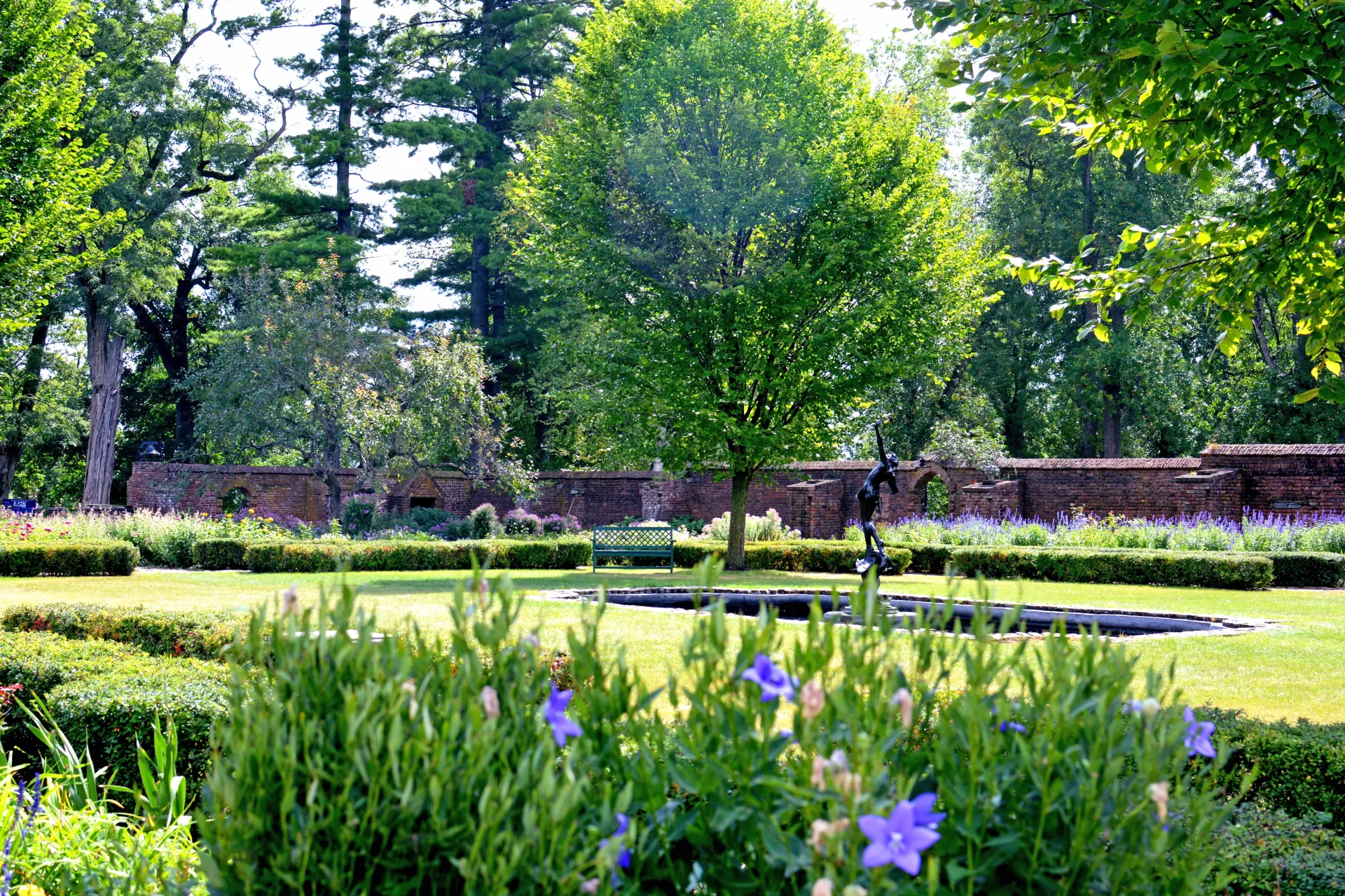 The gardens around Fort Ticonderoga, lush grass, a wadding pool and statues.