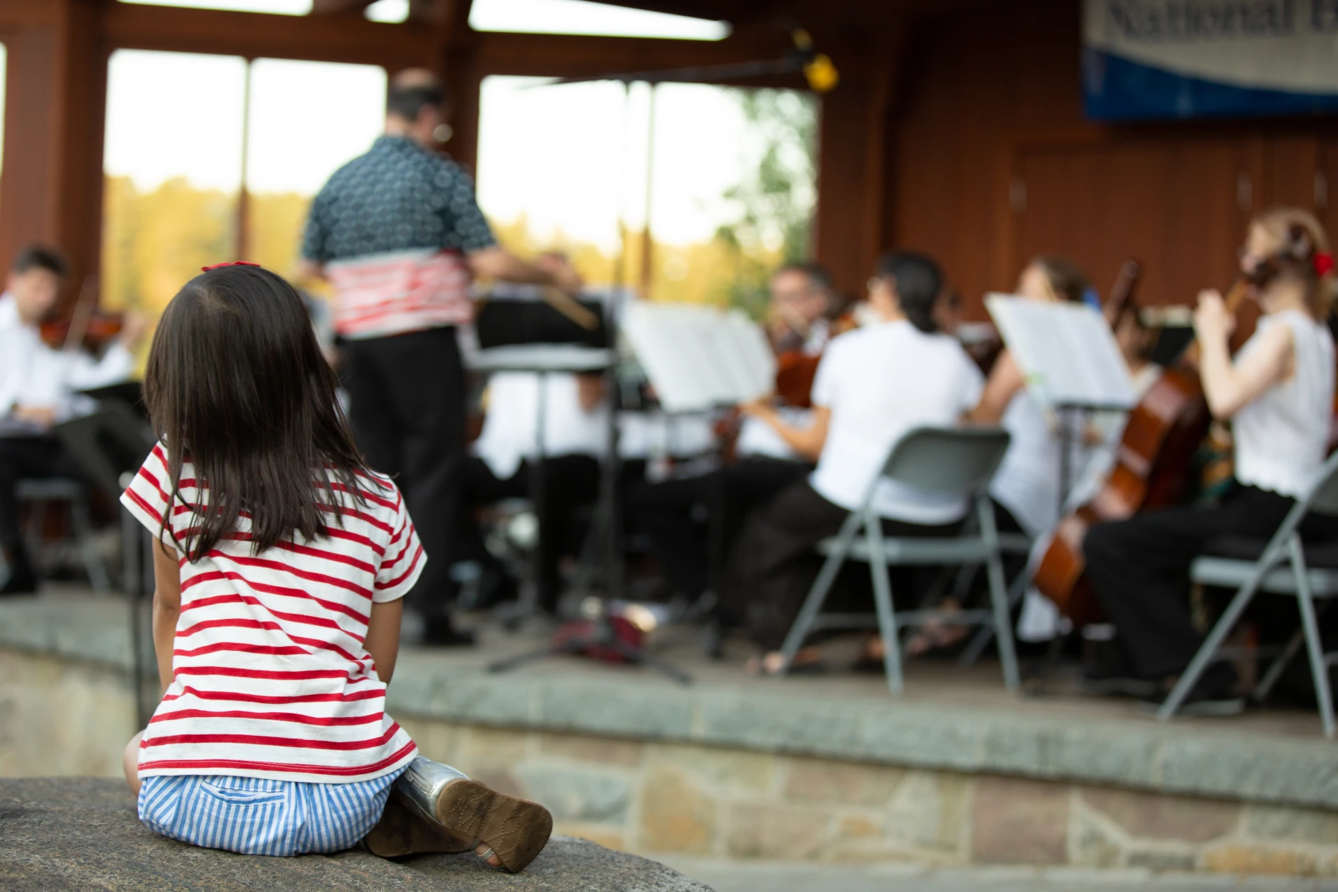 Child watches a band play in the bandshell