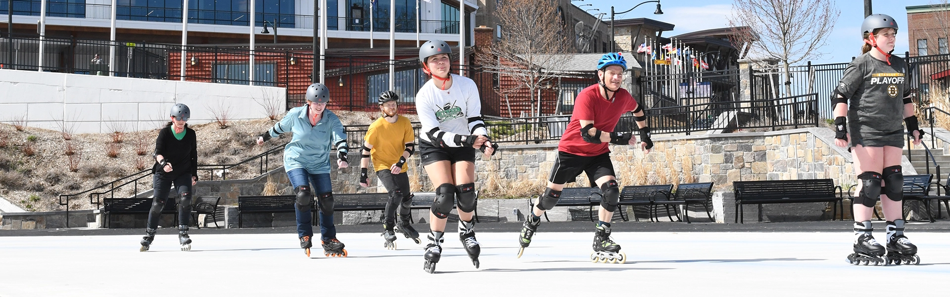 People on roller blades with safety gear enjoying the sun on the James C. Sheffield Speed Skating Oval.