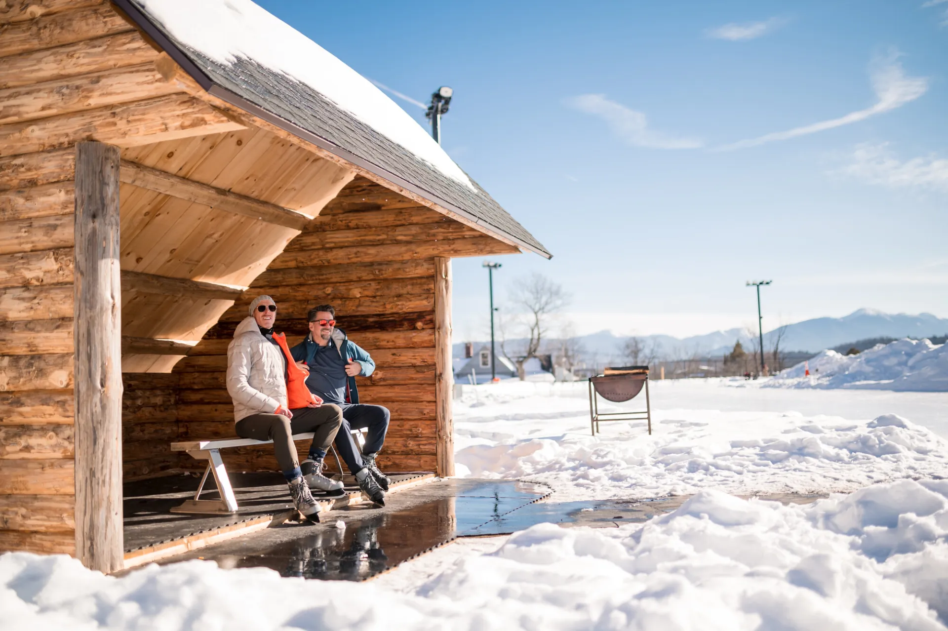 A couple laces up their skates in a lean-to at the Oval