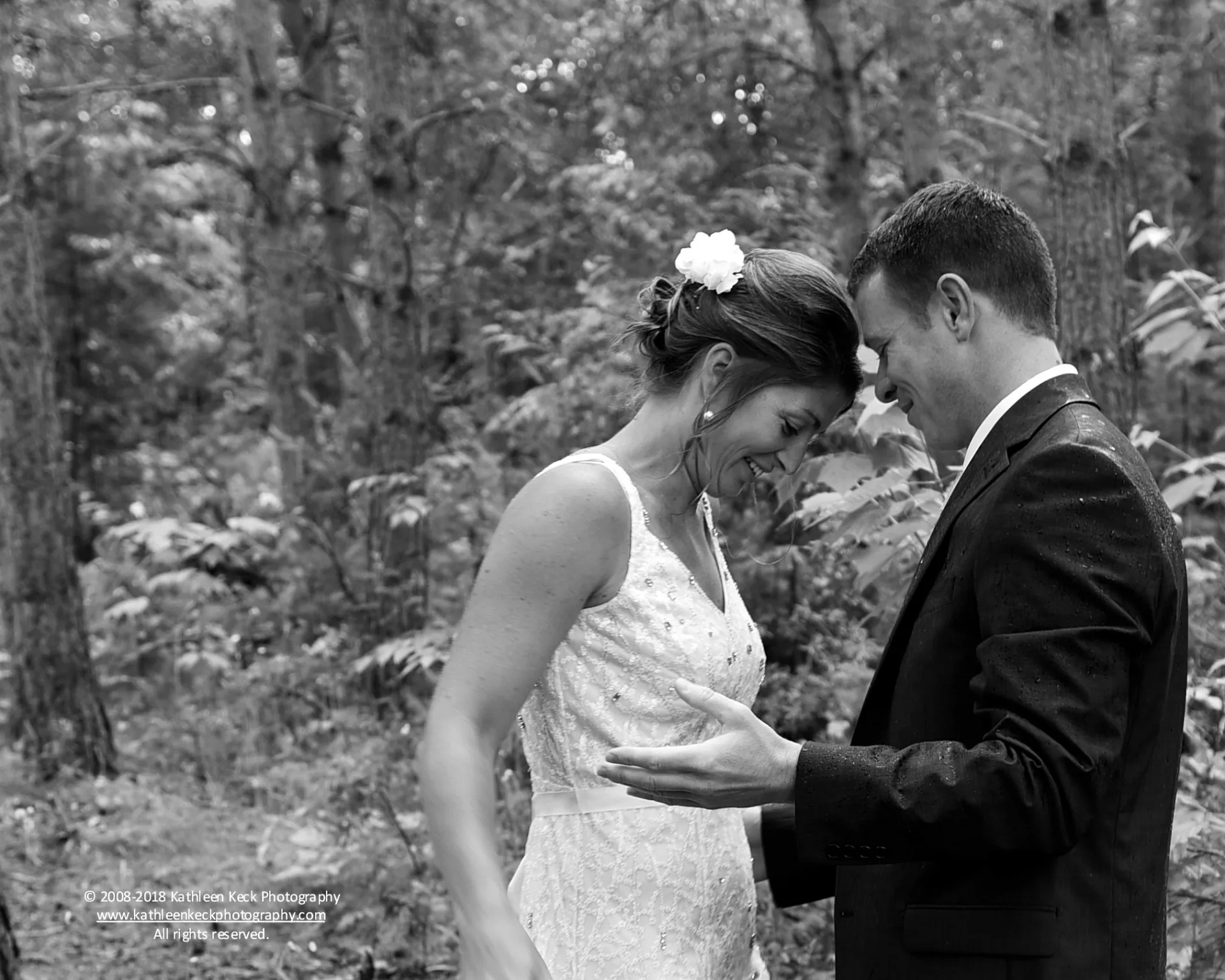 A bride and groom smile at eachother.
