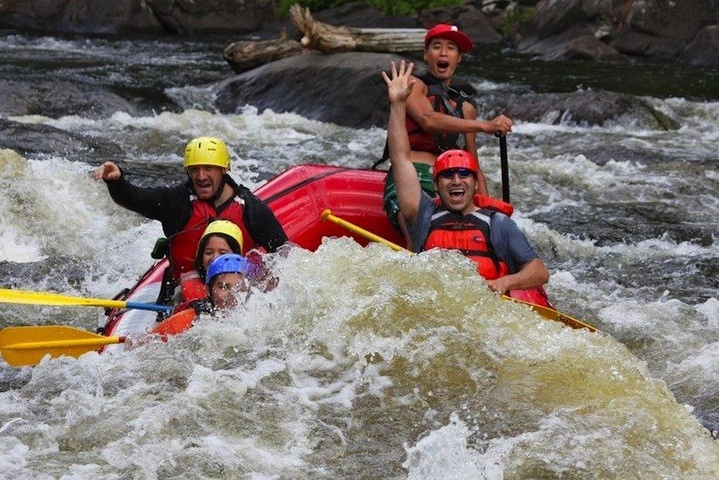 People wave at camera as they pass down the river